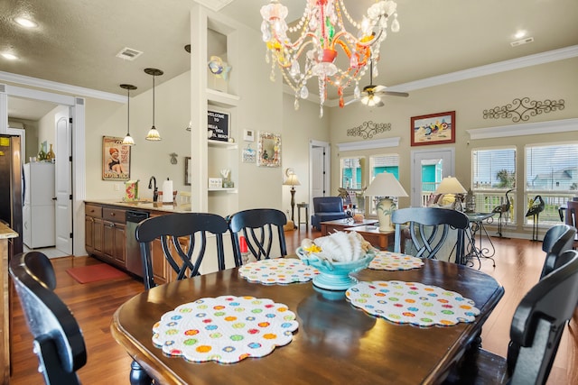 dining space with a textured ceiling, ornamental molding, hardwood / wood-style floors, and ceiling fan with notable chandelier