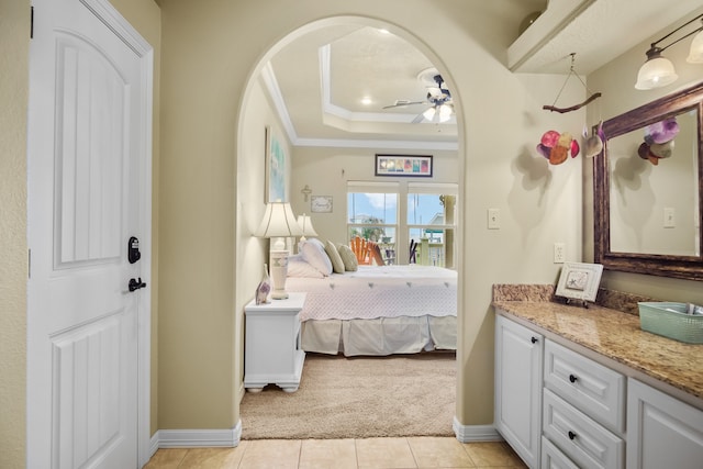 tiled bedroom featuring ceiling fan and a raised ceiling