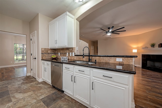 kitchen with stainless steel dishwasher, white cabinetry, kitchen peninsula, and sink