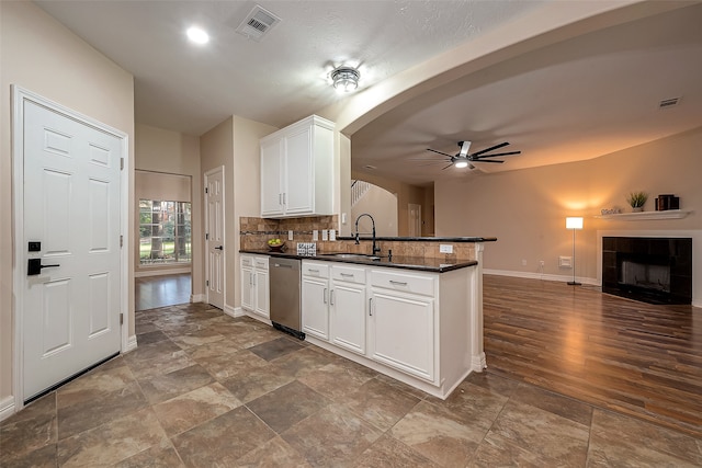 kitchen featuring kitchen peninsula, dishwasher, sink, and white cabinets