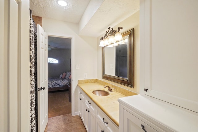 bathroom featuring vanity, a textured ceiling, and tile floors