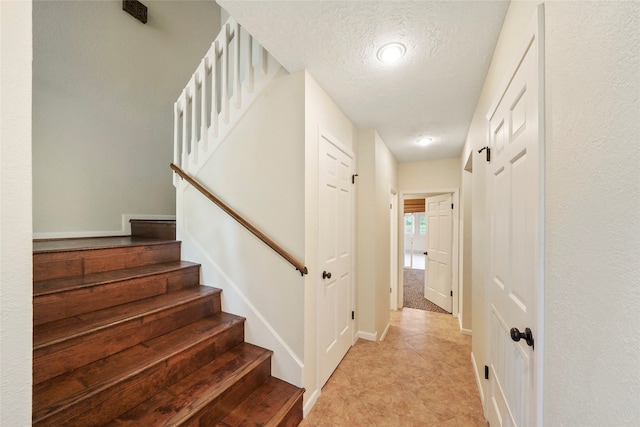 interior space featuring a textured ceiling and light tile floors