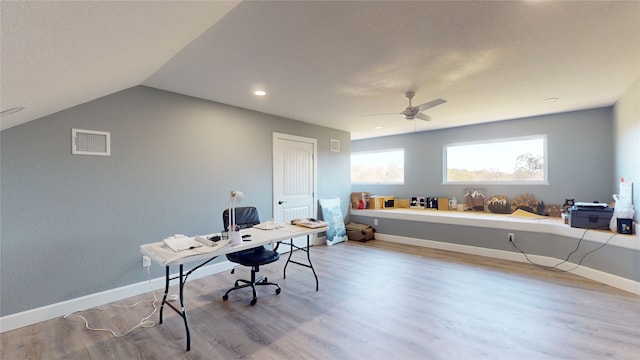 home office with ceiling fan, light hardwood / wood-style flooring, and vaulted ceiling