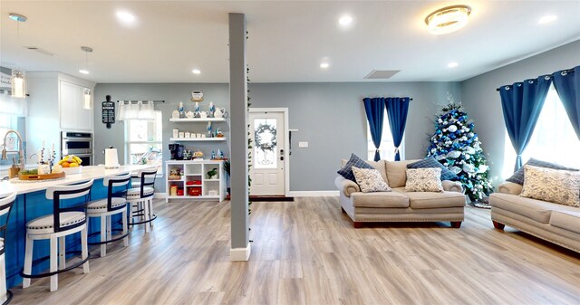 living room featuring sink and light wood-type flooring