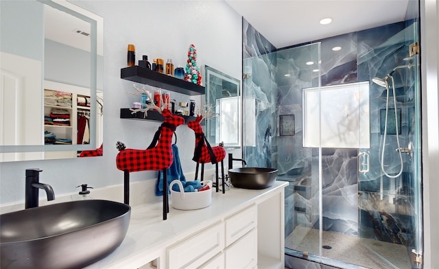 bathroom featuring double sink vanity and a shower with door