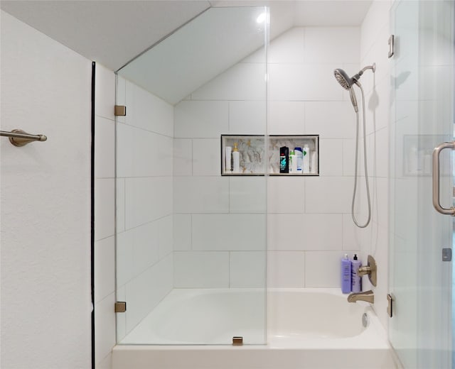 bathroom featuring bath / shower combo with glass door and vaulted ceiling