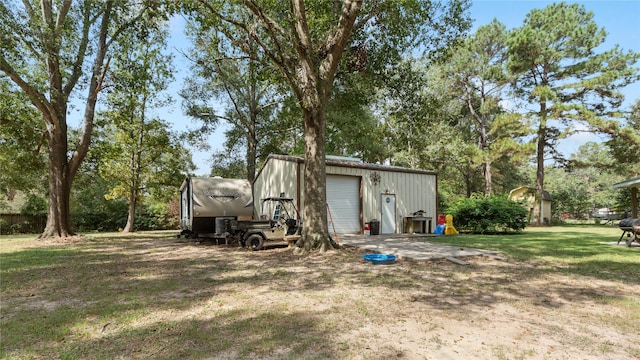 view of yard featuring a garage and an outbuilding