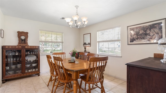 dining space with a notable chandelier and light tile patterned flooring