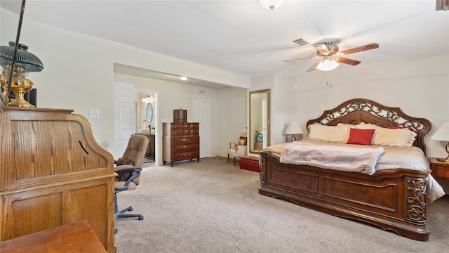 carpeted bedroom featuring ceiling fan and ensuite bath