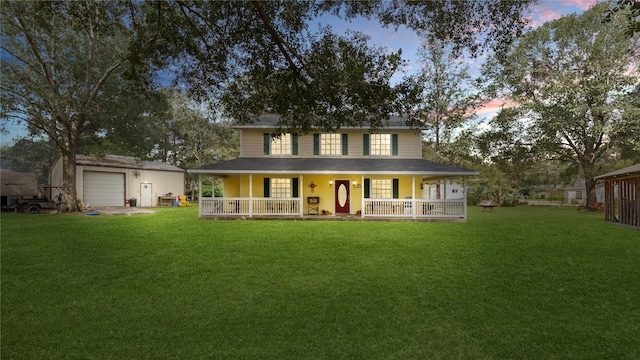 view of front of property featuring a lawn, an outdoor structure, a garage, and a porch