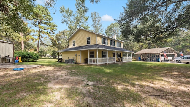 rear view of house with a lawn, a porch, and central AC