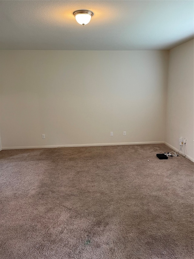 spare room featuring dark carpet