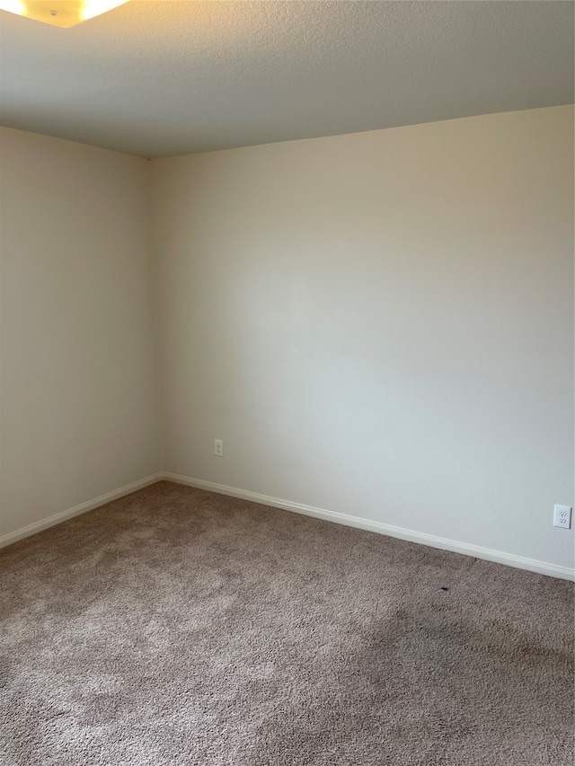 carpeted empty room with a textured ceiling