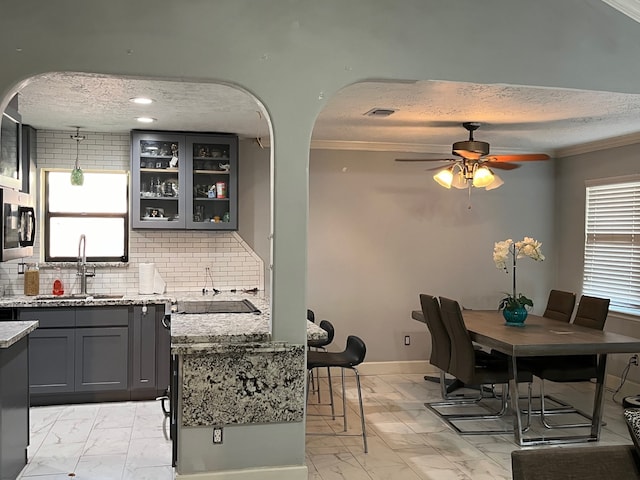 dining area featuring crown molding, sink, ceiling fan, and light tile floors