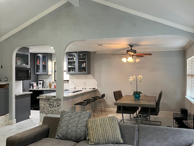 tiled living room with vaulted ceiling, ceiling fan, and crown molding