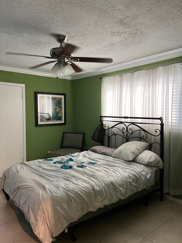 tiled bedroom with ceiling fan, a textured ceiling, and crown molding