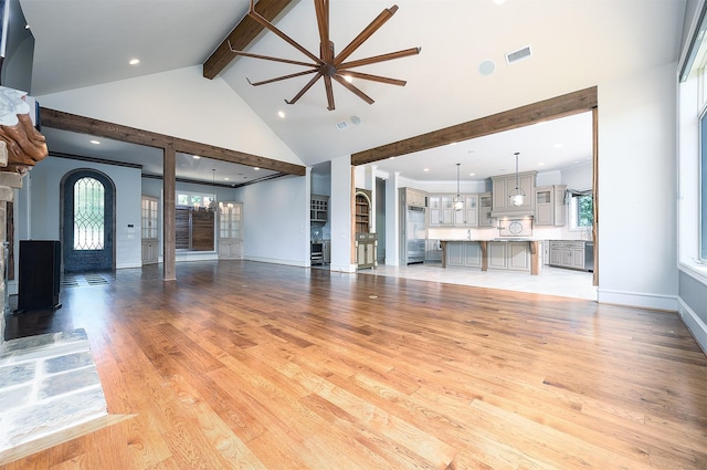 unfurnished living room featuring beam ceiling, high vaulted ceiling, and light hardwood / wood-style flooring