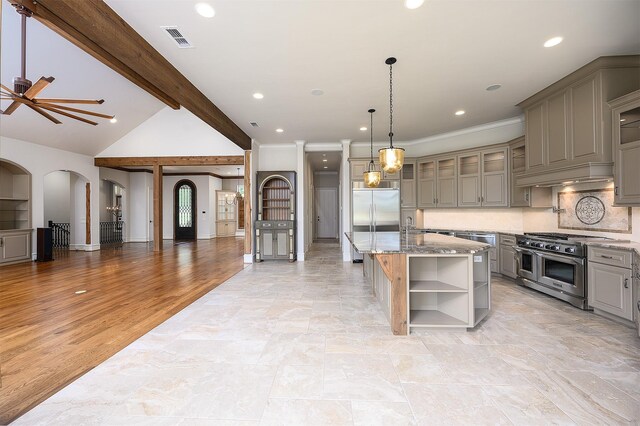 kitchen with light stone counters, a center island, hanging light fixtures, premium appliances, and backsplash