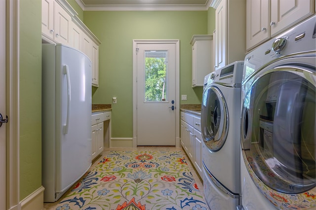 clothes washing area with crown molding, cabinets, light tile patterned flooring, and washing machine and dryer