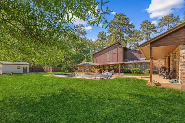 view of yard with a fenced in pool, a storage shed, and a patio