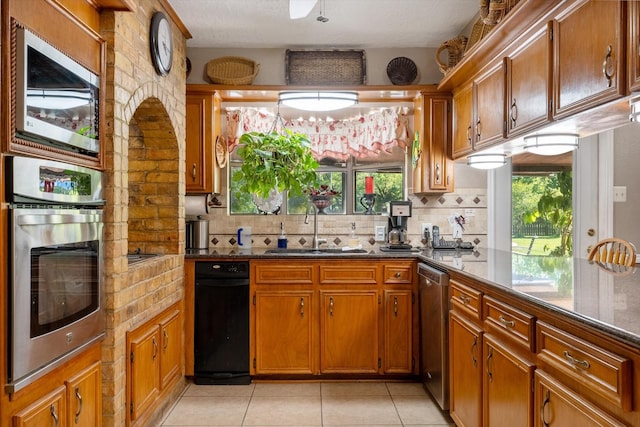 kitchen with light tile patterned flooring, appliances with stainless steel finishes, sink, and decorative backsplash