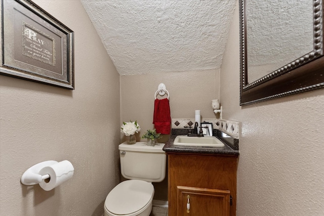 bathroom with vanity, vaulted ceiling, and toilet