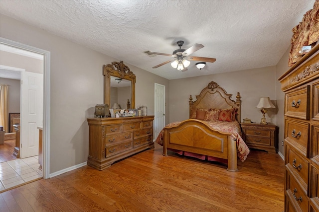 bedroom with ceiling fan, a textured ceiling, and light hardwood / wood-style floors