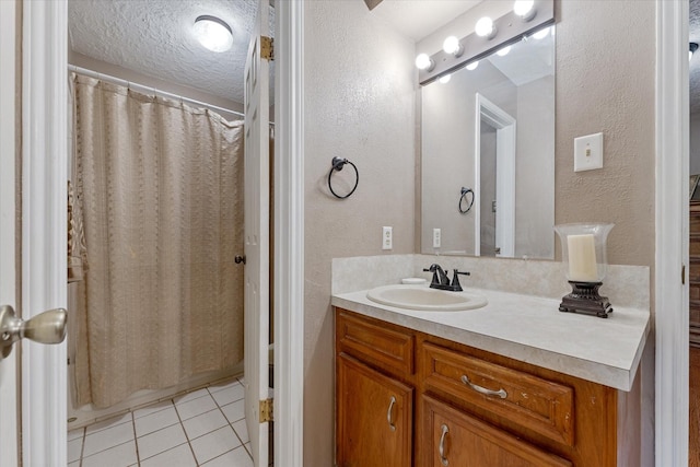 bathroom with a shower with curtain, vanity, tile patterned flooring, and a textured ceiling