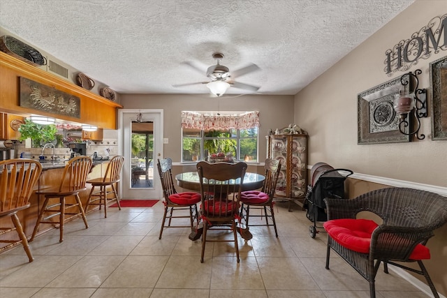 tiled dining room featuring sink, a textured ceiling, and ceiling fan