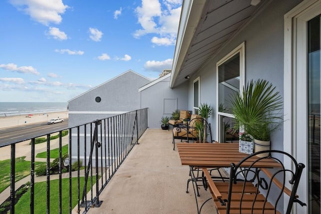 balcony featuring a water view and a beach view