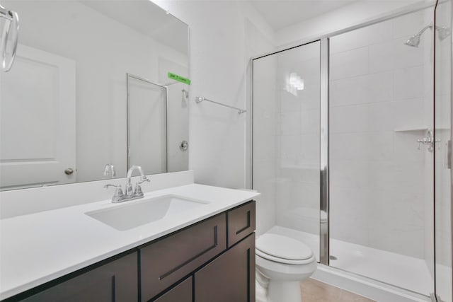 bathroom featuring vanity, toilet, tile patterned floors, and a shower with shower door