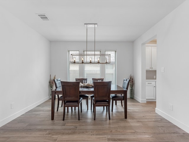 dining room featuring light hardwood / wood-style floors and a chandelier