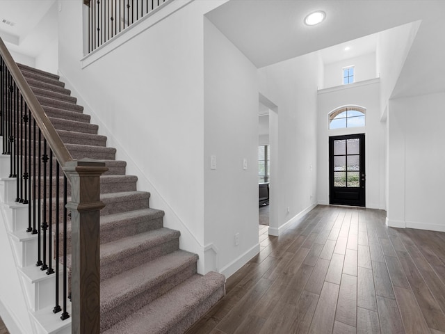 foyer entrance with dark hardwood / wood-style floors and a high ceiling