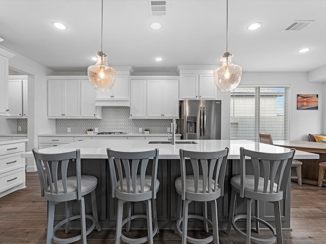 kitchen with backsplash, hanging light fixtures, dark wood-type flooring, and appliances with stainless steel finishes