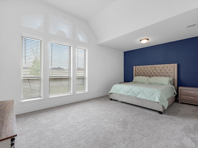 bedroom featuring light carpet and vaulted ceiling