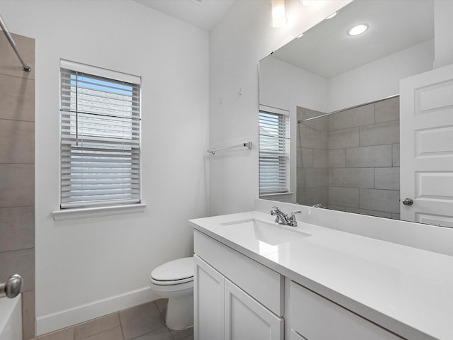 bathroom featuring toilet, tile flooring, large vanity, and a wealth of natural light