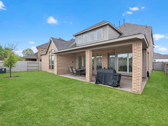 rear view of property featuring a lawn and a patio