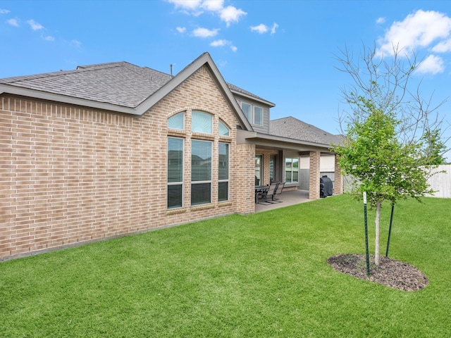 back of property with a patio area and a yard