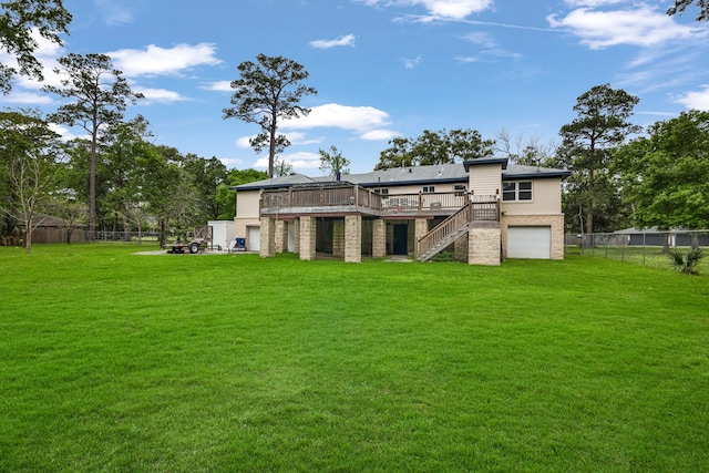 rear view of property featuring a wooden deck and a lawn