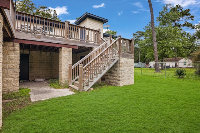 back of house featuring a lawn and a wooden deck