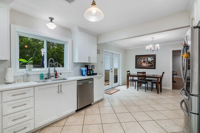 kitchen with appliances with stainless steel finishes, sink, white cabinetry, and hanging light fixtures