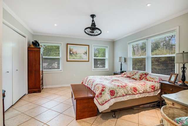 tiled bedroom featuring crown molding and a closet