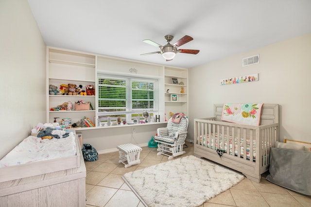 tiled bedroom with ceiling fan and a nursery area