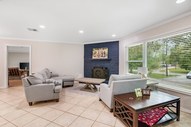 living room with brick wall, a brick fireplace, plenty of natural light, and light tile floors