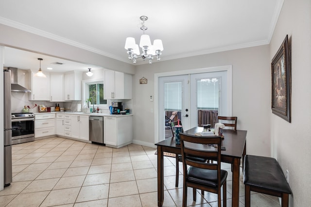 kitchen with hanging light fixtures, an inviting chandelier, stainless steel appliances, wall chimney range hood, and french doors