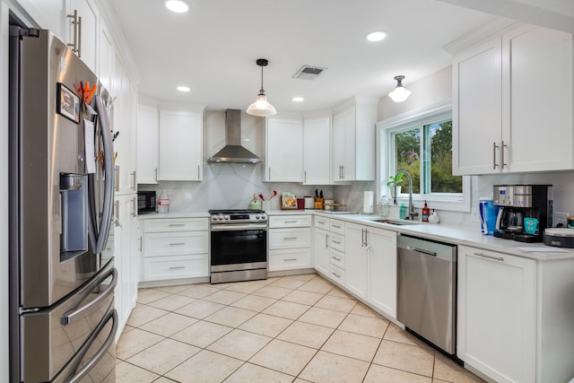 kitchen with hanging light fixtures, backsplash, stainless steel appliances, white cabinets, and wall chimney exhaust hood