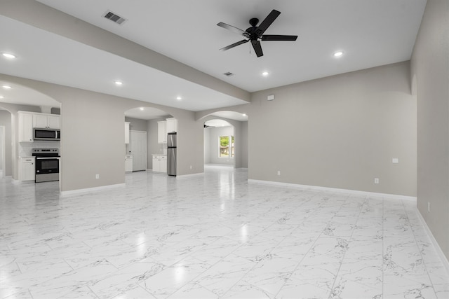 unfurnished living room with light tile flooring and ceiling fan