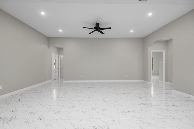 tiled spare room featuring ceiling fan