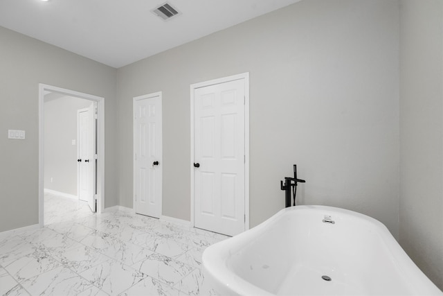 bathroom featuring a bath and tile floors