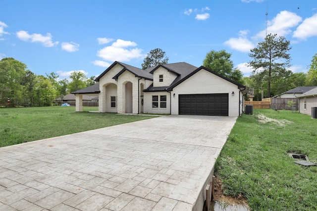 view of front of property featuring central AC, a front lawn, and a garage